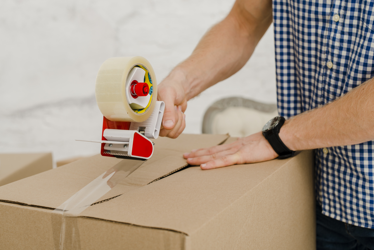 man packing box with tape