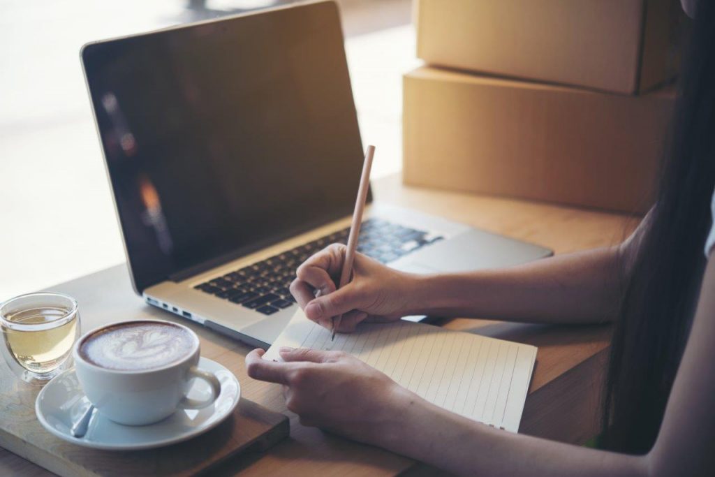 woman writing on notepad