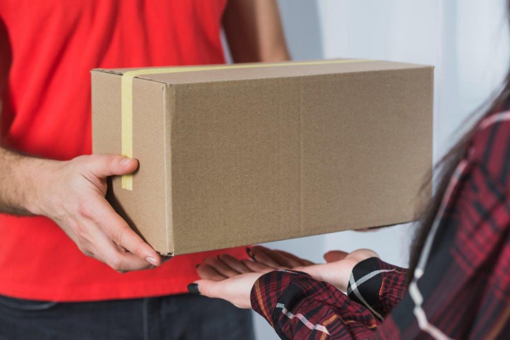 delivery man giving package to woman