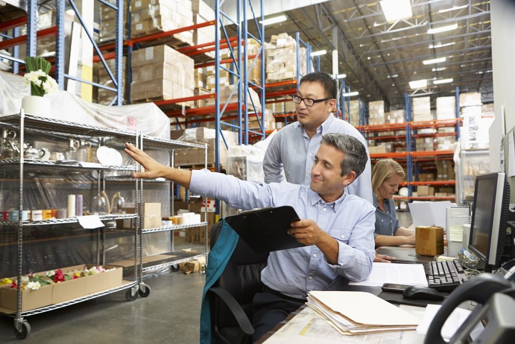 Business Colleagues Working At Desk In Warehouse